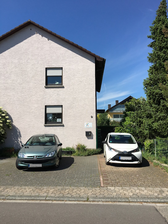 2 Pkw auf einem Parkplatz vor der Ergotherapiepraxis Hölderlinstraße 9 in Heppenheim