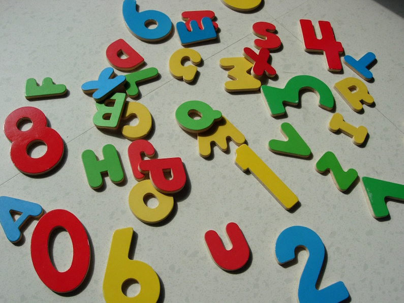 bunte Holzbuchstaben und -zahlen auf dem Fußboden